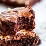 Stack of brownies with bite out of top one.