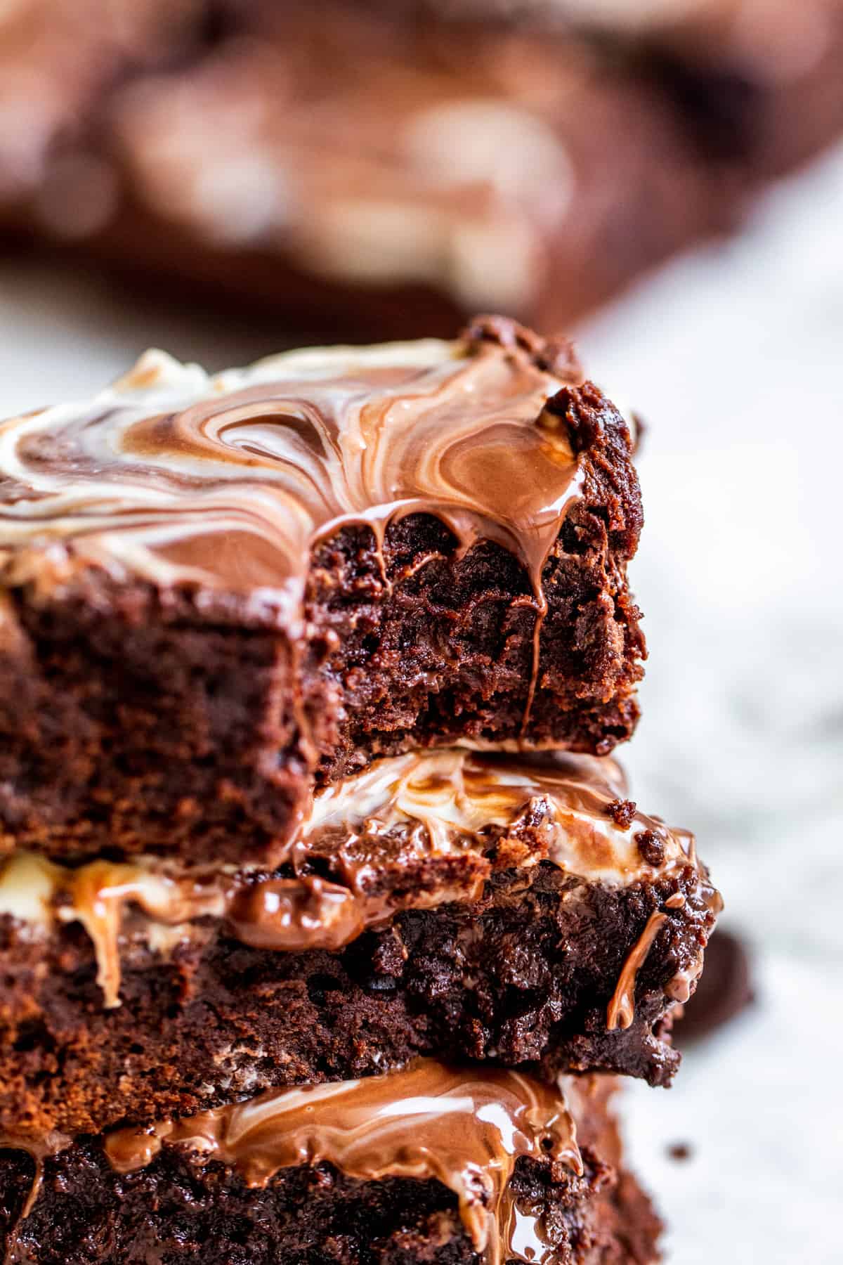 Stack of brownies with bite out of top one.