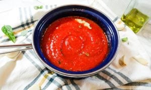 Marinara sauce in a small blue pot. 