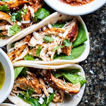 Overhead shot of tacos on a dark marble counter.