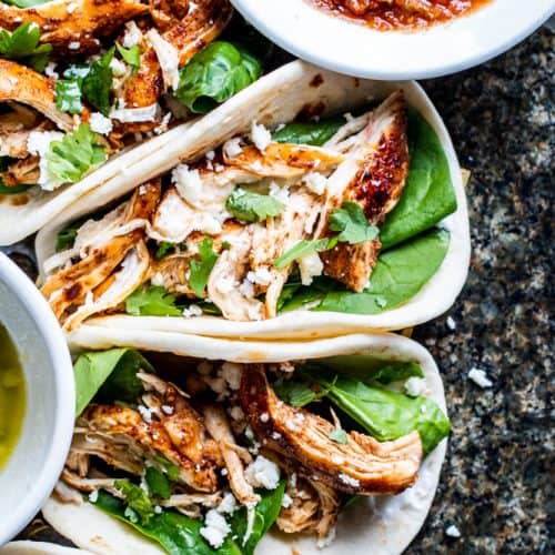 Overhead shot of tacos on a dark marble counter.