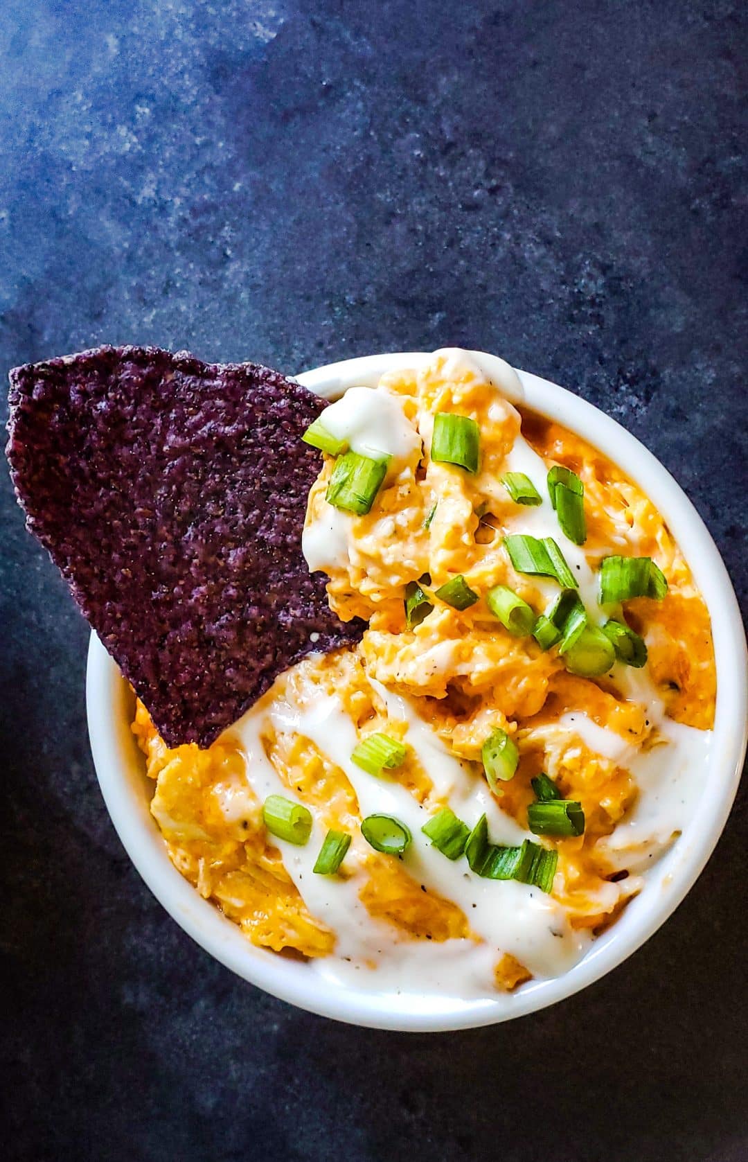 Dip in a white bowl with a blue chip sticking out.