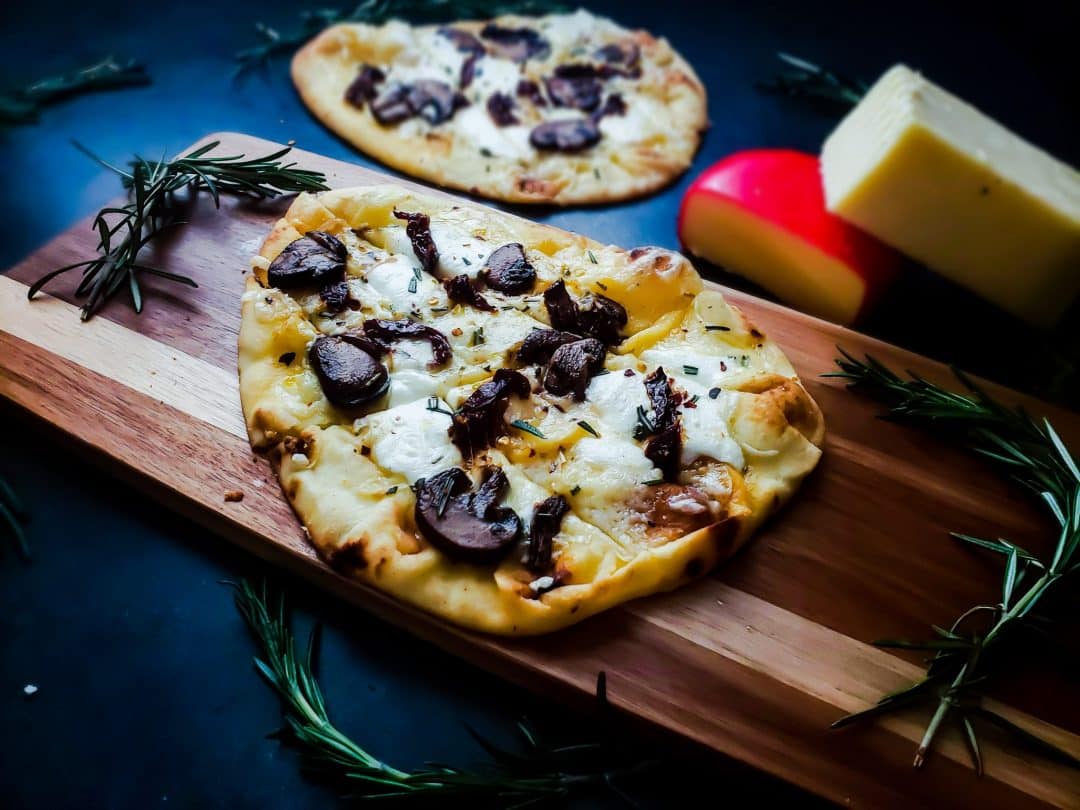 This vegetarian flatbread pizza recipe is healthy, easy and fast! The pizza works great as a dinner recipe or as an appetizer. This pizza has three types of cheese, an olive oil based sauce and mushrooms and fresh rosemary!