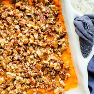Overhead shot of sweet potato casserole in a white baking dish on a white counter.