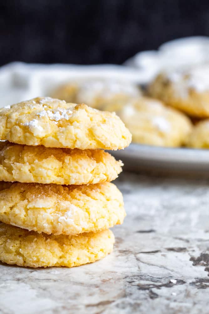 Stack of gooey butter cake cookies with plate blurred out in the background.