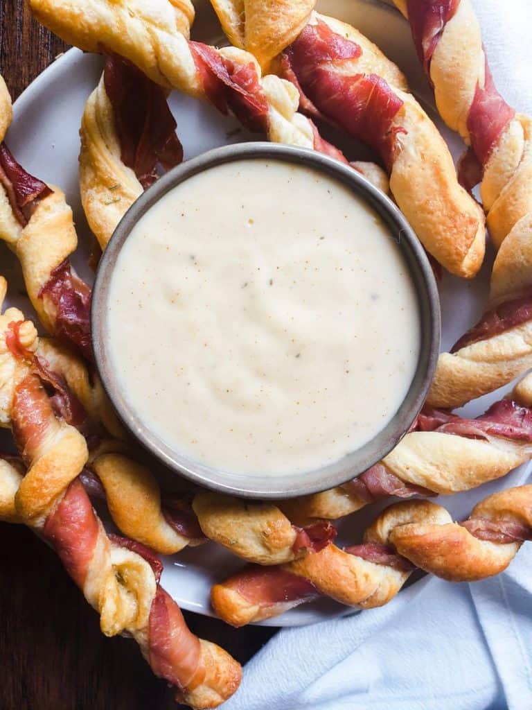 Overhead shot of breadsticks and cheese on a white plate.