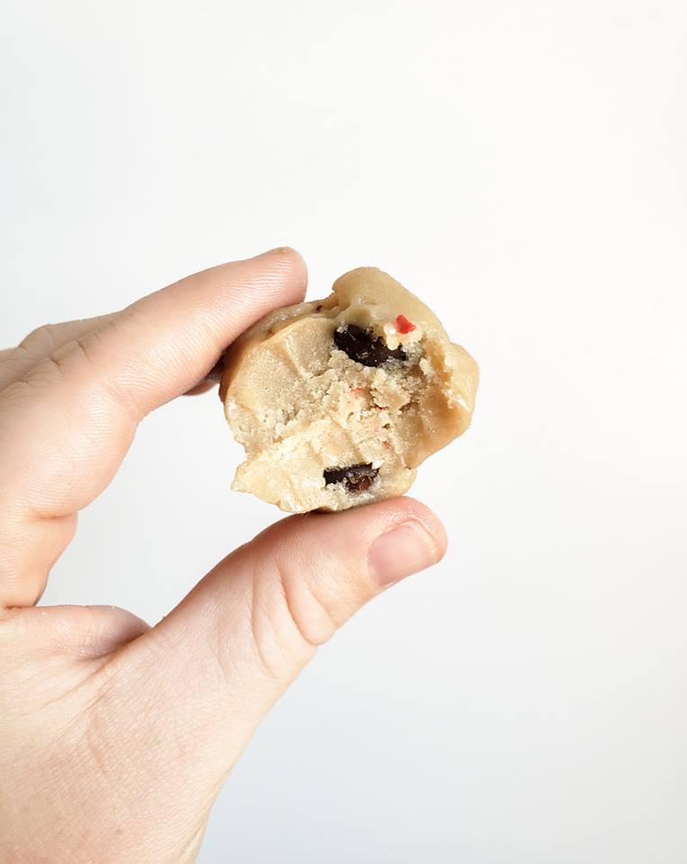 Hand holding ball of cookie dough.