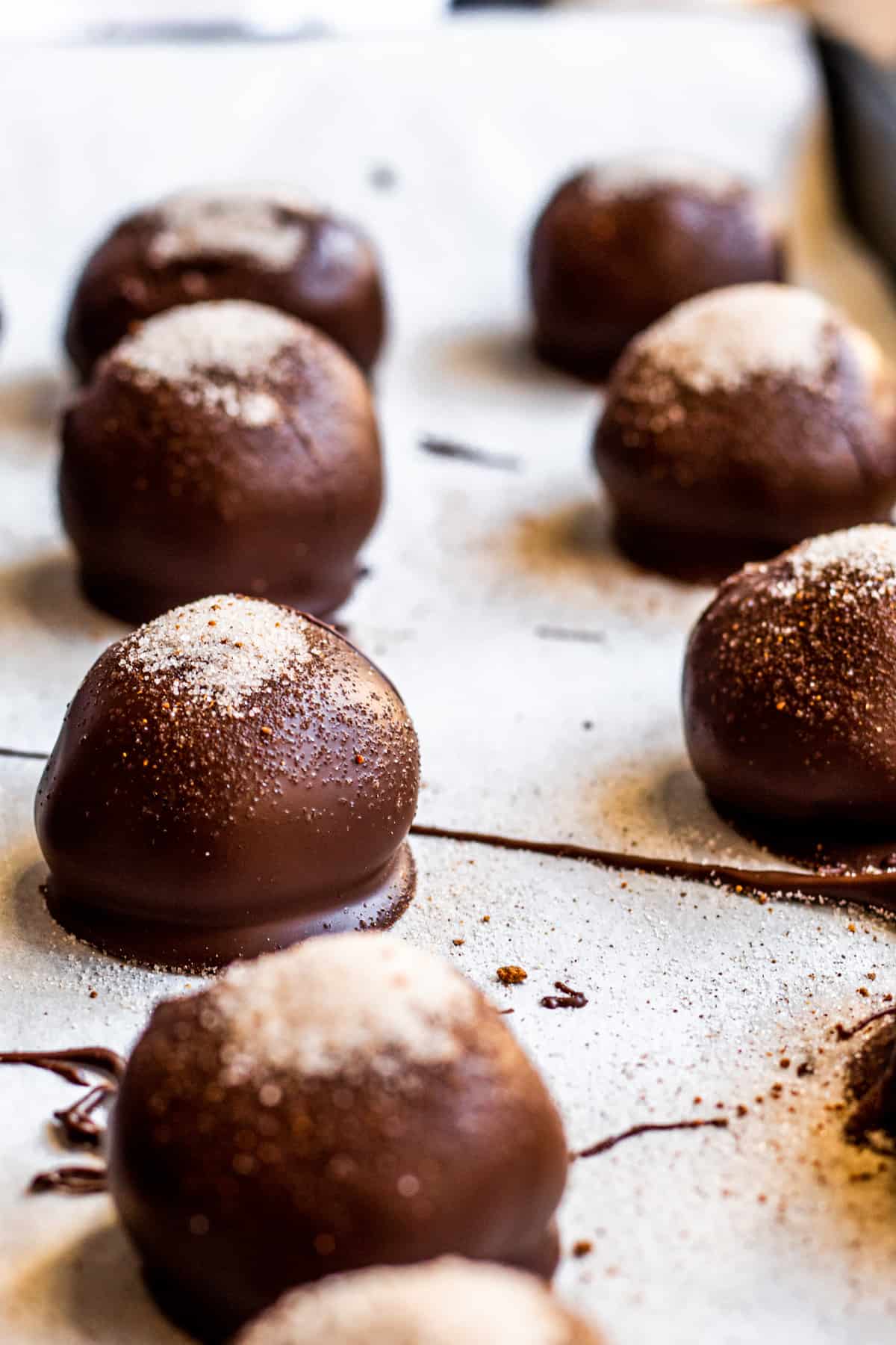 Truffles on parchment paper in rows.