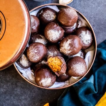 Overhead shot of truffles in tin on blue counter.