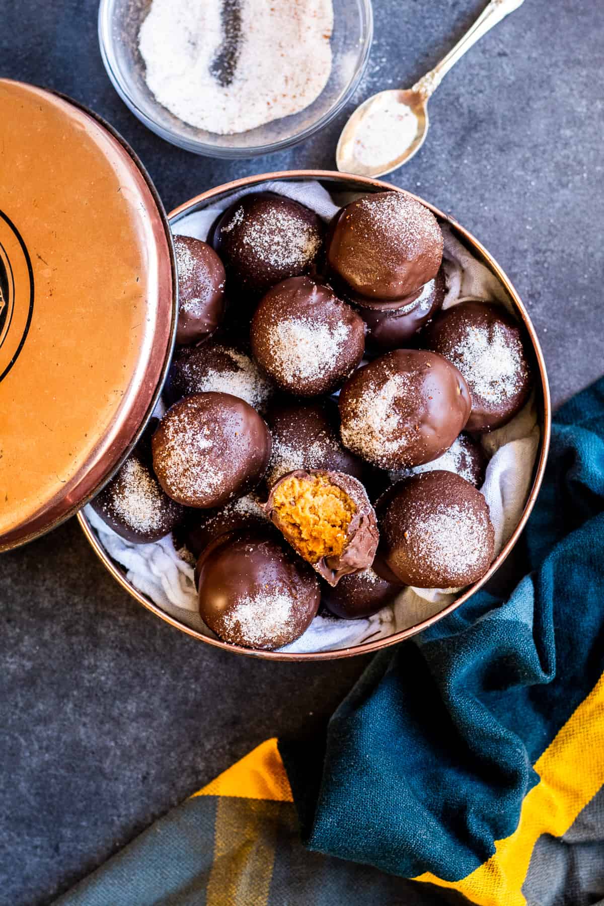 Overhead shot of truffles in tin on blue counter.