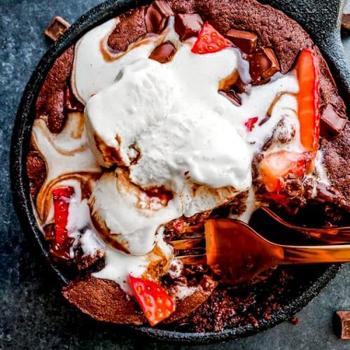 This Skillet Brownie Sundae for Two is the perfect date-night dessert for Valentine's Day! This recipe combines chocolate, ice cream, hot fudge and strawberries in a tiny iron skillet for the perfect indulgent treat! #ValentinesDay #Dessert #Brownie #ForTwo #SmallBatch