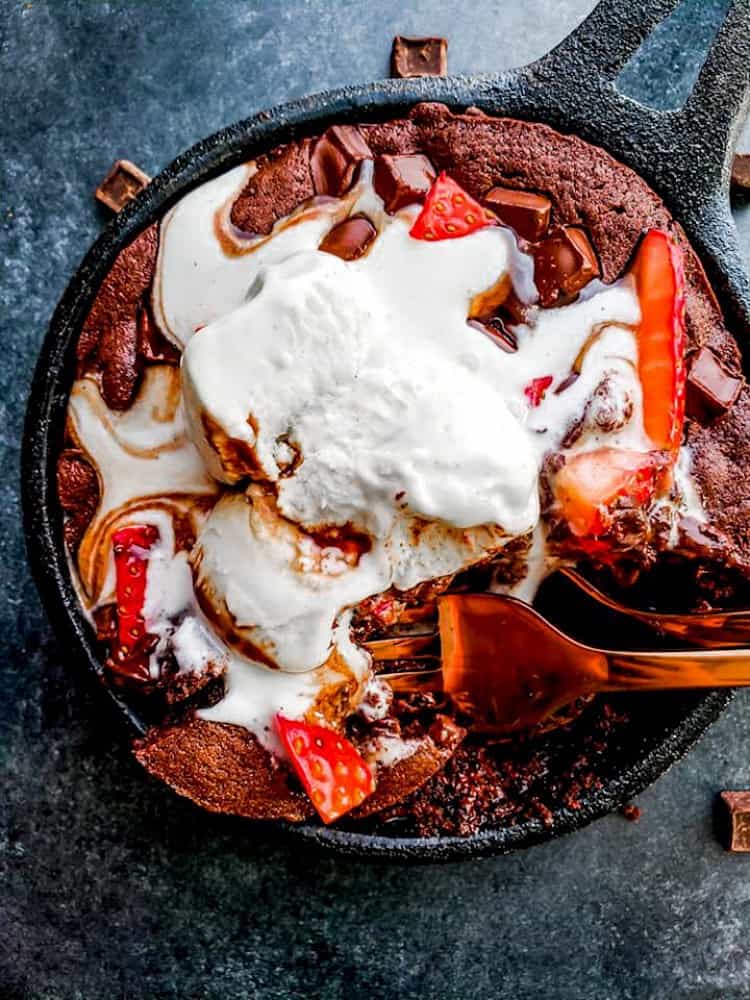 This Skillet Brownie Sundae for Two is the perfect date-night dessert for Valentine's Day! This recipe combines chocolate, ice cream, hot fudge and strawberries in a tiny iron skillet for the perfect indulgent treat! #ValentinesDay #Dessert #Brownie #ForTwo #SmallBatch