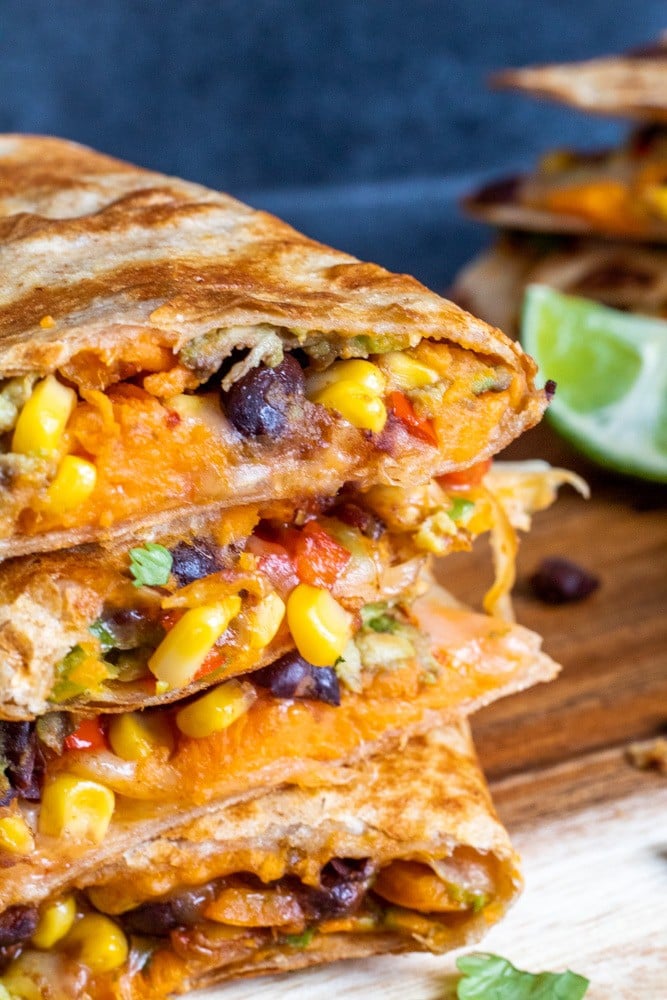 Close up shot of Vegetarian Quesadillas on a cutting board with blue background.