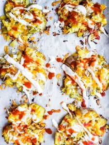 Smashed potatoes on a parchment paper lined pan. 