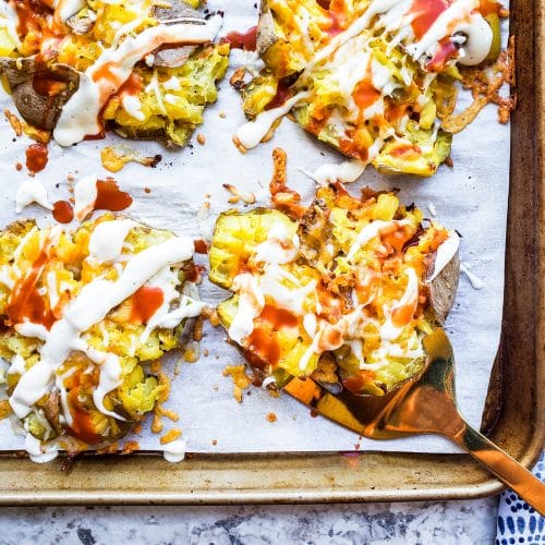 These Crispy Smashed Potatoes with Cheesy Buffalo Sauce is the perfect side dish recipe to pair with any family dinner. Boiled then baked in the oven these will become your favorite! #potatoes #food #sidedish