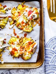 Potatoes on pan with white towel and gold spatula on the right side out of frame.