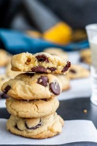 Stack of cookie on a piece of parchment paper with more in the background.