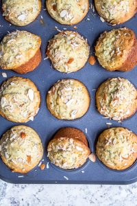 This Almond Poppy Seed Muffins recipe is easy, fast and perfect for breakfast, brunch, snacks of a dessert. These muffins are also great for toddlers and the rest of your family. #vegetarian #muffins #breakfast #snacks #almonds Overhead shot of muffins in the pan with some turned.