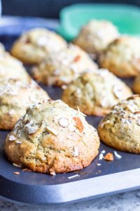 This Almond Poppy Seed Muffins recipe is easy, fast and perfect for breakfast, brunch, snacks of a dessert. These muffins are also great for toddlers and the rest of your family. #vegetarian #muffins #breakfast #snacks #almonds Close up shot of almond poppy seed muffins in the baking pan.