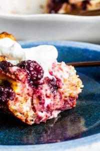 Baked French Toast on a blue plate with white dish in the background. 