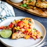 This Cilantro Lime Grilled Chicken recipe is perfect all summer long! Pair with Strawberry Pineapple Salsa for a healthy and fresh combo perfect on its own, with tacos, in burrito bowls, or in a salad! The marinade is simple and fast and can be made ahead of time for easy prep. Give this recipe a try at your next family BBQ, party or 4th of July cookout. #healthy #ChickenRecipes #BBQ #Salsa #glutenfree