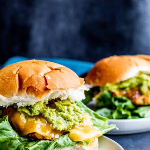 These Grilled Chicken Burgers with Guacamole and Garlic Aioli are the best summer grill burger for the entire family. The meat is juicy and filled with flavor and pairs perfect with store bought or homemade guacamole, Gouda cheese, lettuce and homemade garlic aioli. Don't have a grill? No problem, make on the stove top as well! #burgers #grilling #food #recipe #chicken