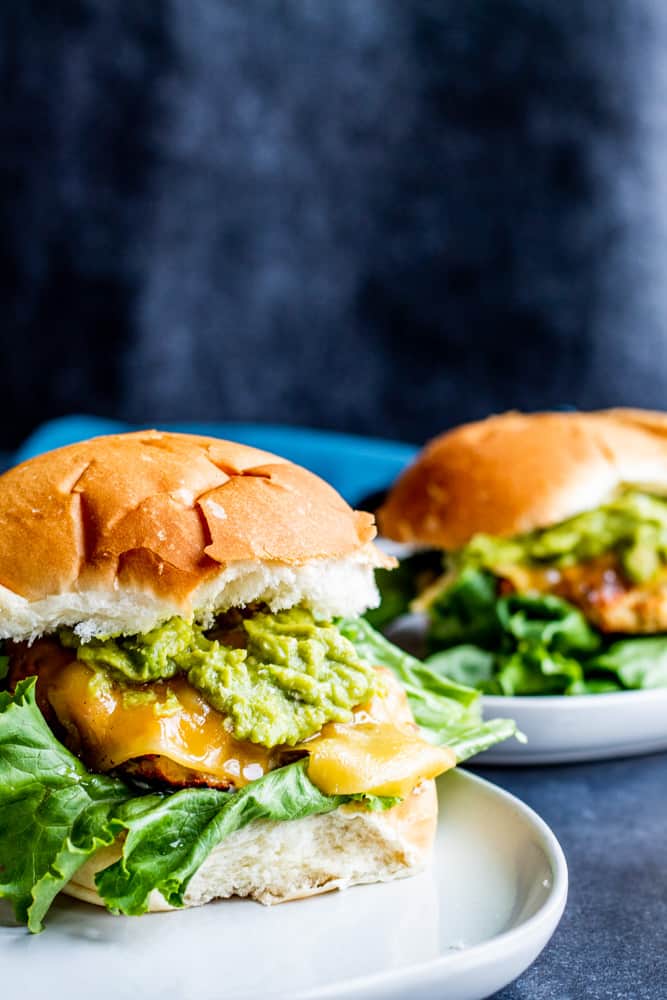 These Grilled Chicken Burgers with Guacamole and Garlic Aioli are the best summer grill burger for the entire family. The meat is juicy and filled with flavor and pairs perfect with store bought or homemade guacamole, Gouda cheese, lettuce and homemade garlic aioli. Don't have a grill? No problem, make on the stove top as well! #burgers #grilling #food #recipe #chicken