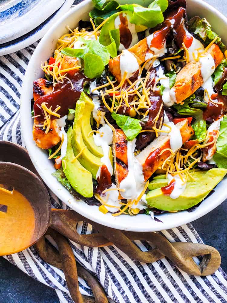 Overhead shot of salad in white bowl with wooden spoons.