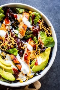 BBQ Chicken salad in a white bowl on a blue counter.