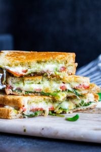 Strait on shot of stacked grilled cheese sandwiches with a dark blue background.