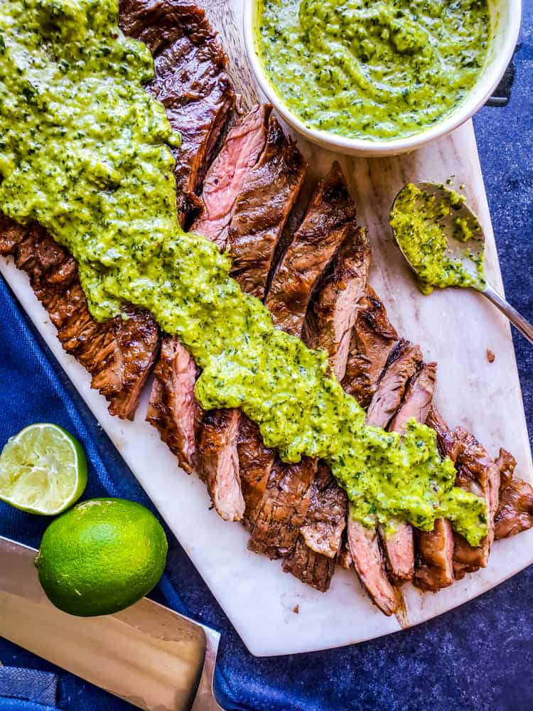 This Grilled Skirt Steak recipe with Chimichurri Sauce is the best summer BBQ recipe for your family and friends! Easy how to steps and tips for tender meat perfect for tacos, fajitas, meal prep, or on its own. The marinade is packed with orange juice, olive oil, soy sauce and garlic and pairs great with so many Mexican dishes. #lowcarb #skirtsteak #BBQ #paleo #keto #food #meatrecipes #dinnerrecipes