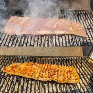 Prep image for grilled skirt steak recipe. Image shows meat on a charcoal grill.