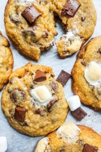 Overhead shot of cookies on white parchment paper, with on cut in half.