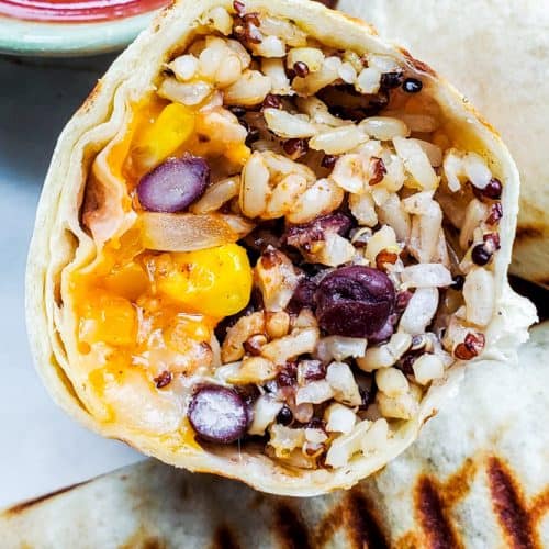 This healthy and easy Vegetarian Burritos recipe is freezer friendly, perfect for meal prep, to make ahead, and super delicious. Packed with black beans, brown rice, quinoa, veggies, cheese and Mexican spices this will be a new family dinner or lunch favorite. Pair with salsa, sour cream or guacamole for the best finish! {VIDEO} #burritos #vegetarian #healthy #mealprep #freezermeal