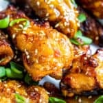 Close up shot of several chicken wings with sesame seeds.