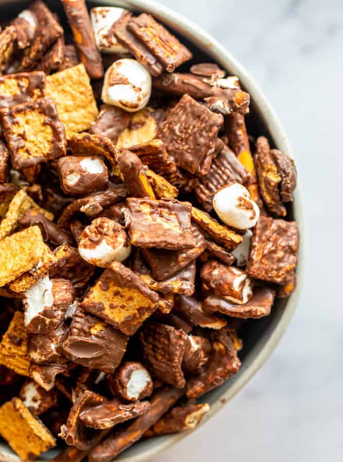 Overhead shot of snack mix in a bowl on a white counter.