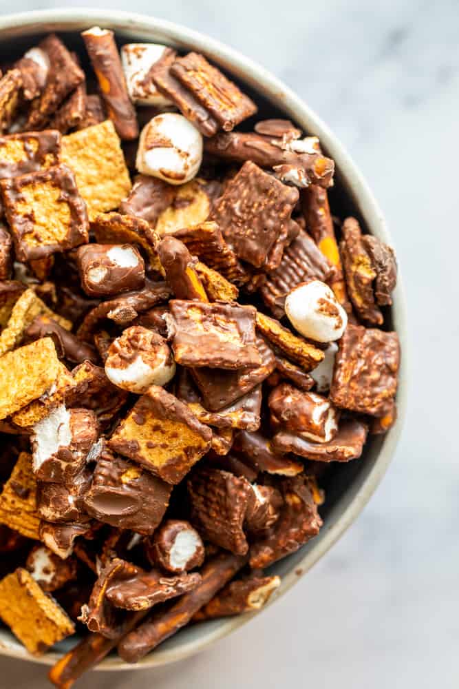 Overhead shot of s'mores snack mix in a white bowl on a white counter.