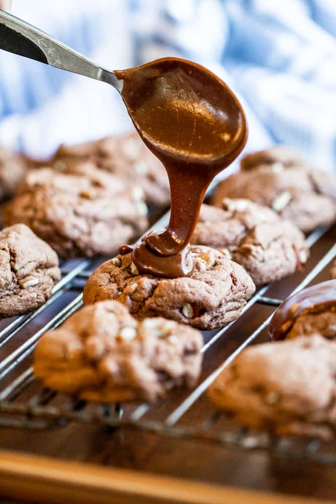 Spoon drizzle cookie with chocolate icing on a cooling rack.