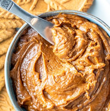 Overhead shot of cookie butter in a bowl with a silver knife in it.