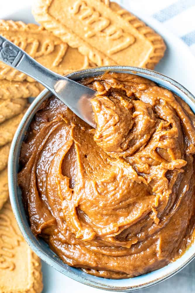 Overhead shot of cookie butter in a bowl with a silver knife in it.