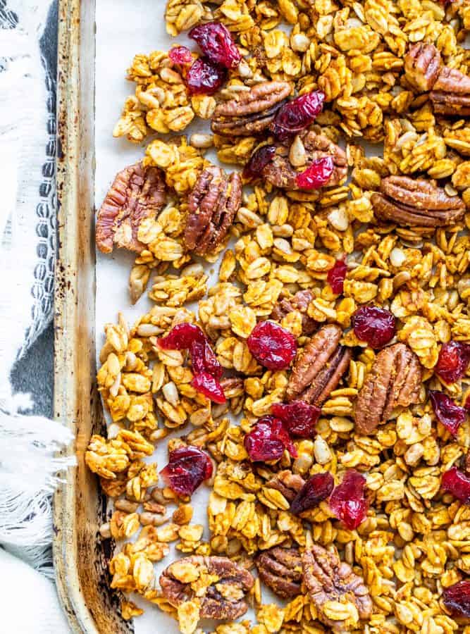 Overhead shot of pumpkin spice granola on a tray with towel.