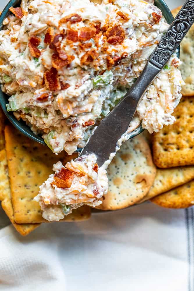 Overhead shot of bacon spread on silver knife resting on bowl.