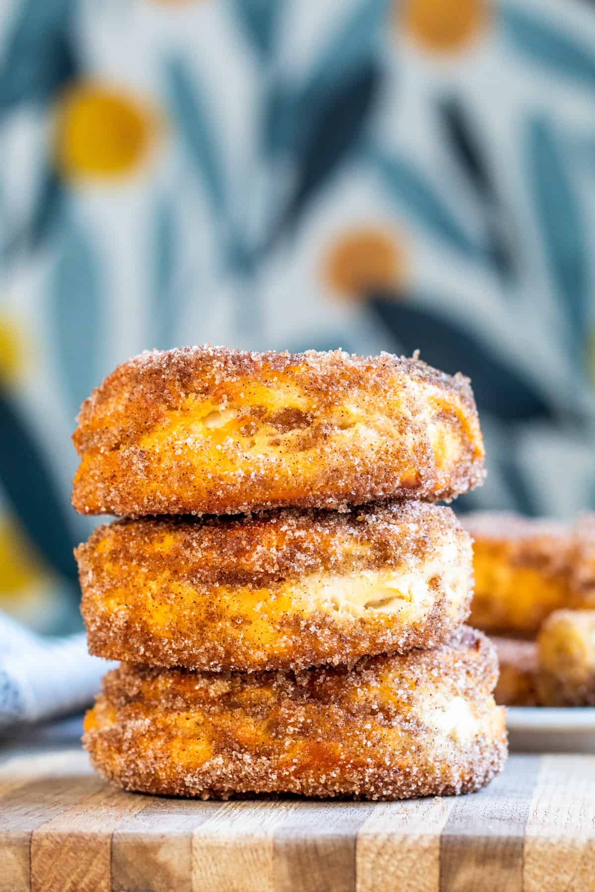 Cinnamon Sugar donuts in stack with blue floral background.