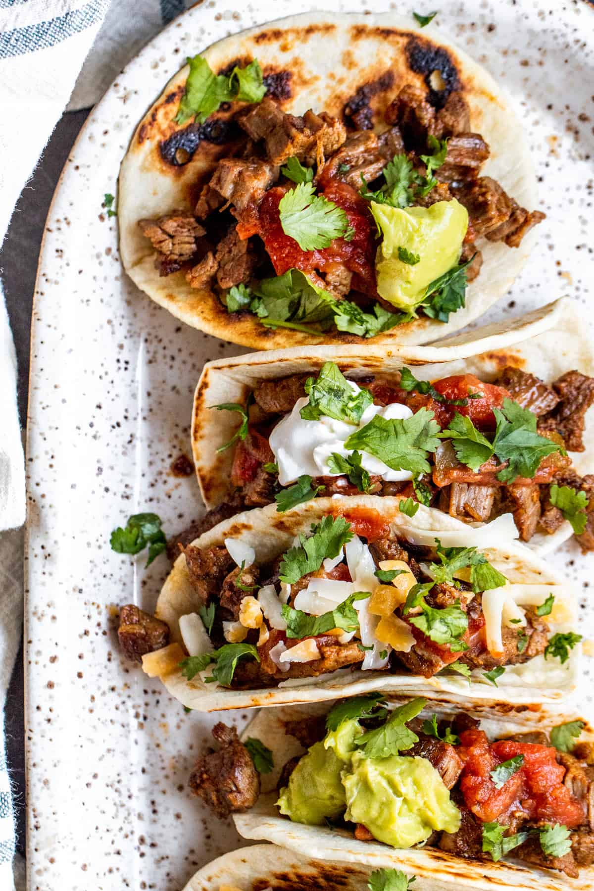 Overhead shot of tacos on a white serving tray.