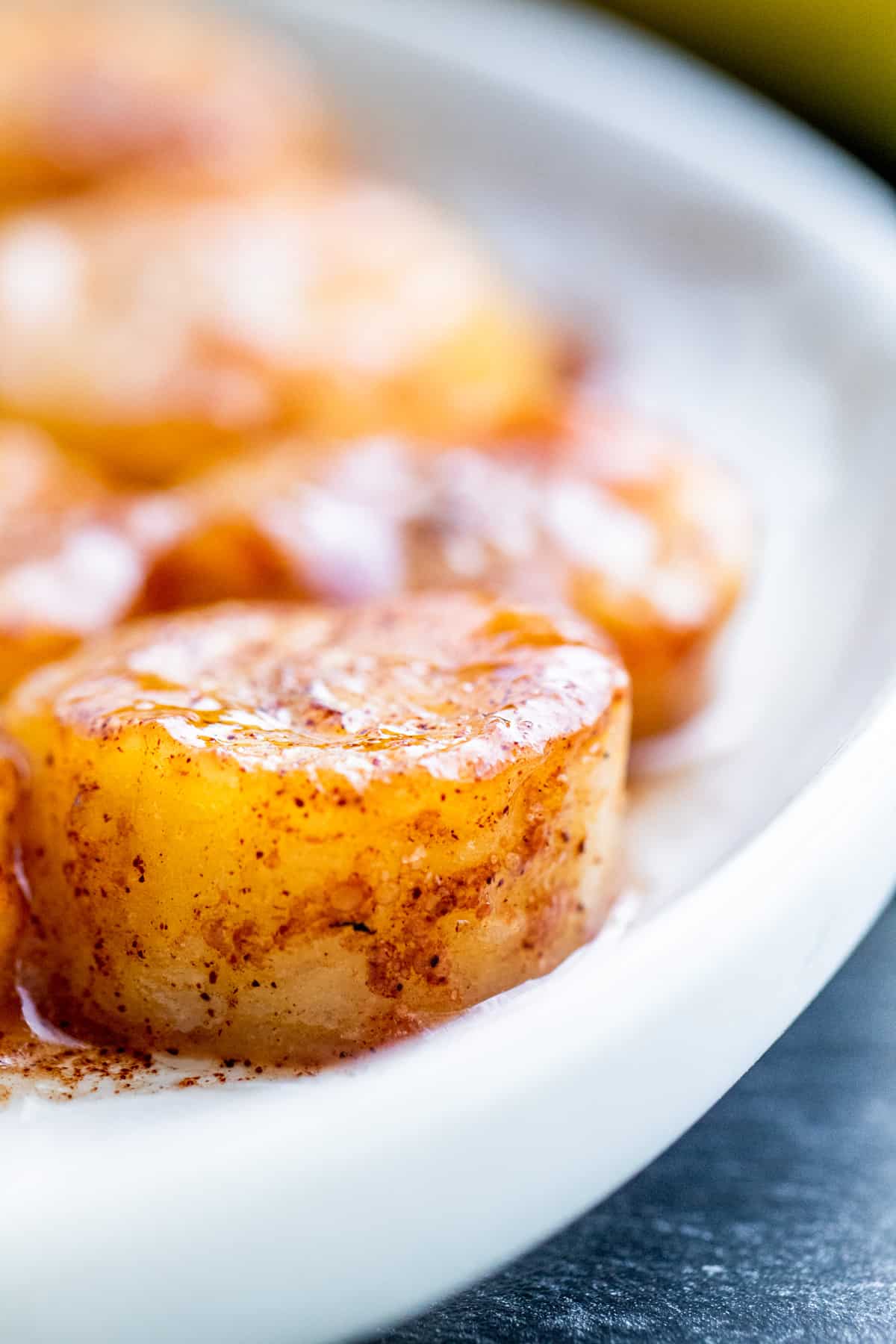 Close up shot of fried banana on white plate.