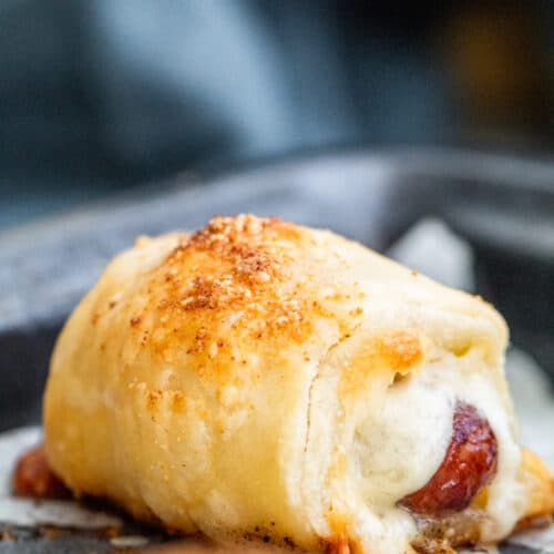 Close up show of pigs in a blanket with parchment paper.