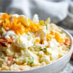 Close up angle of potato salad in white bowl.