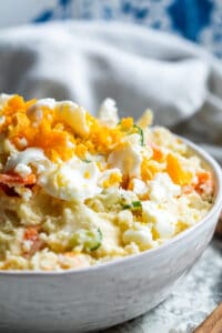 Close up angle of potato salad in white bowl.