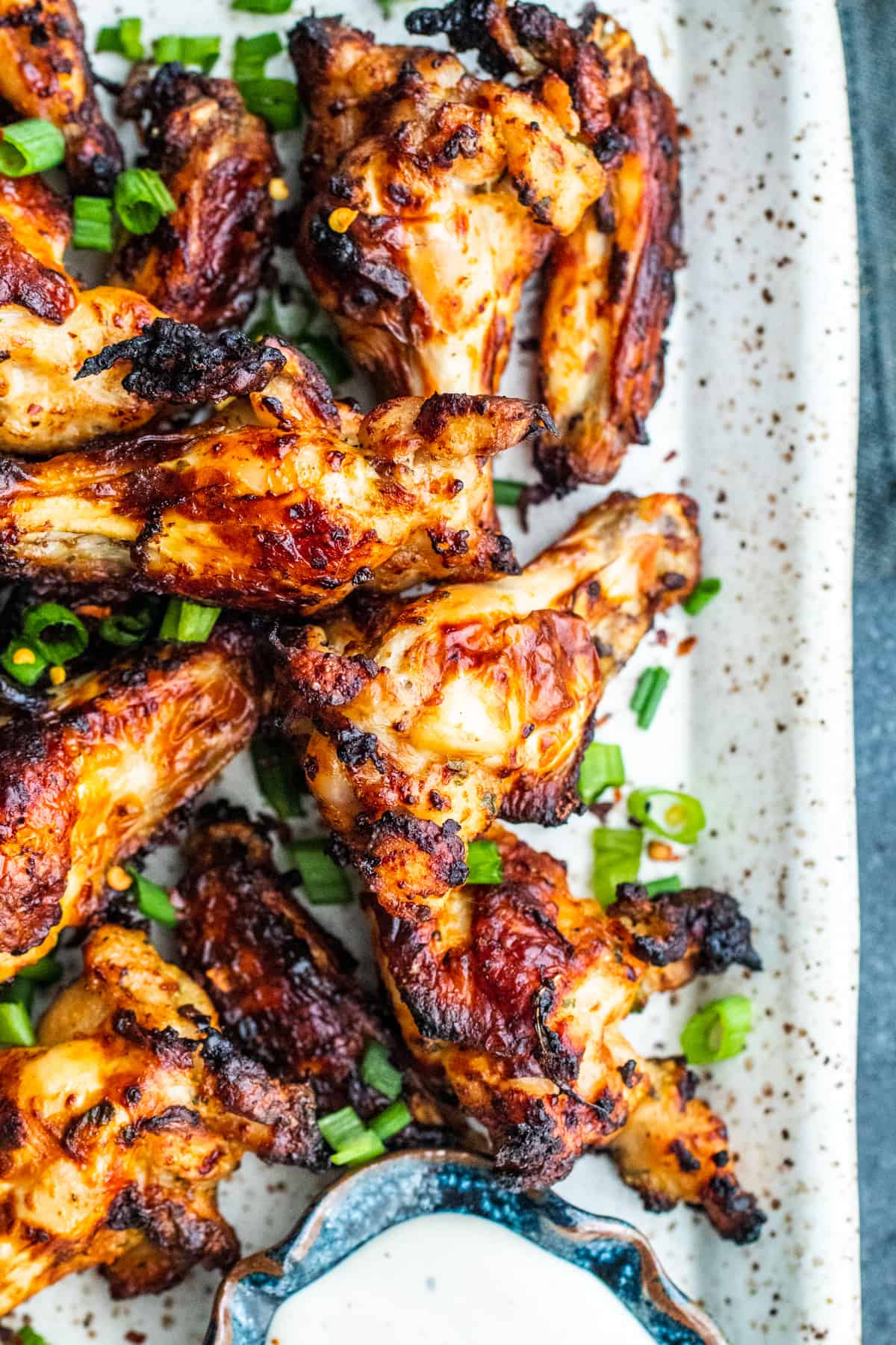 Overhead shot of wings on a white platter with ranch.