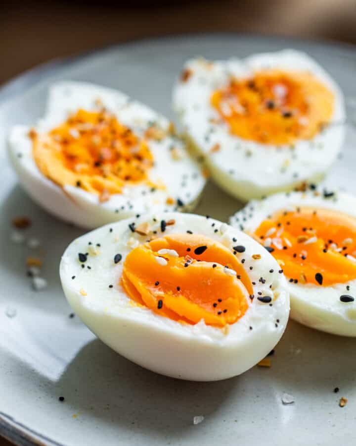 Close up of sliced hard boiled eggs on gray plate.